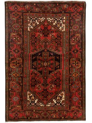 Tappeto persiano khamse rosso, con medaglione centrale stilizzato a forma di fiore e motivi decorativi floreali stilizzati su tutto il campo e lo spesso brodo del tappeto