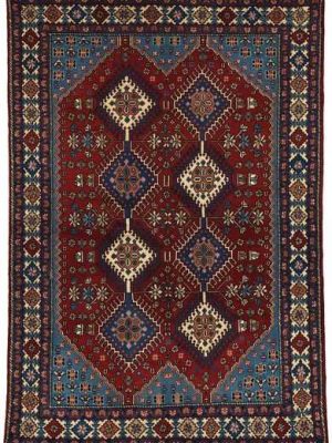 Tappeto persiano originale yalameh con motivi decorativi geometrici a rombo uncinati su campo rosso e motivi floreali stilizzati, e spesso bordo decorato a rombi