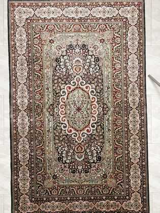 Tappeto persiano hereke seta con medaglione centrale e intricati motivi decorativi floreali su tutto il campo e il bordo del tappeto