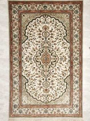 Tappeto persiano hereke di seta con medaglione centrale su fondo bianco e intricati dettagli decorativi floreali su tutto il campo e il bordo bianco del tappeto