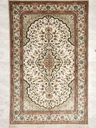 Tappeto persiano hereke di seta con medaglione centrale su fondo bianco e intricati dettagli decorativi floreali su tutto il campo e il bordo bianco del tappeto