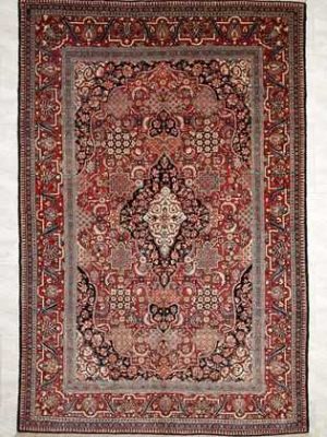 Tappeto keshan antico con medaglione centrale bianco e blu su campo rosso e intricati dettagli decorativi sul campo e lo spesso bordo del tappeto