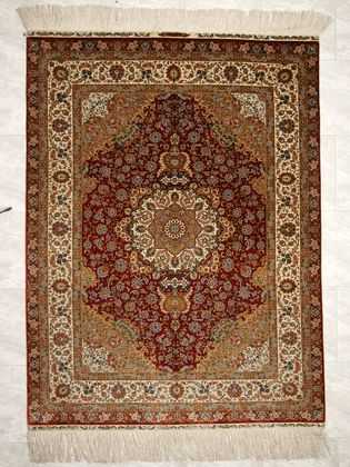 Tappeto hereke seta ouzipek con medaglione centrale bianco e oro su fondo rosso e intricati dettagli decorativi sul doppio bordo bianco e rosso e sul campo e il medaglione del tappeto