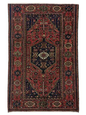 Tappeto persiano Hamadan con medaglione centrale geometrico blu su sfondo rosso, con motivi decorativi geometrici stilizzati sul campo rosso e sullo spesso bordo del tappeto