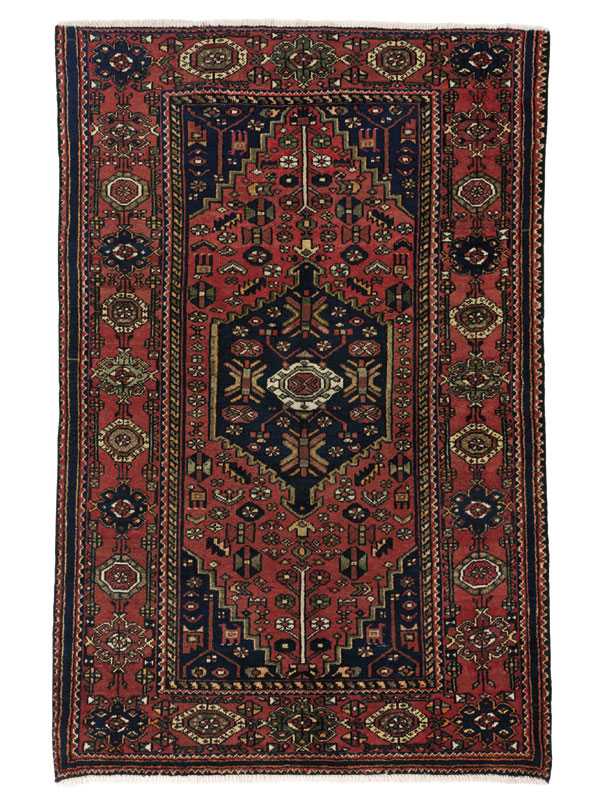 Tappeto persiano Hamadan con medaglione centrale geometrico blu su sfondo rosso, con motivi decorativi geometrici stilizzati sul campo rosso e sullo spesso bordo del tappeto