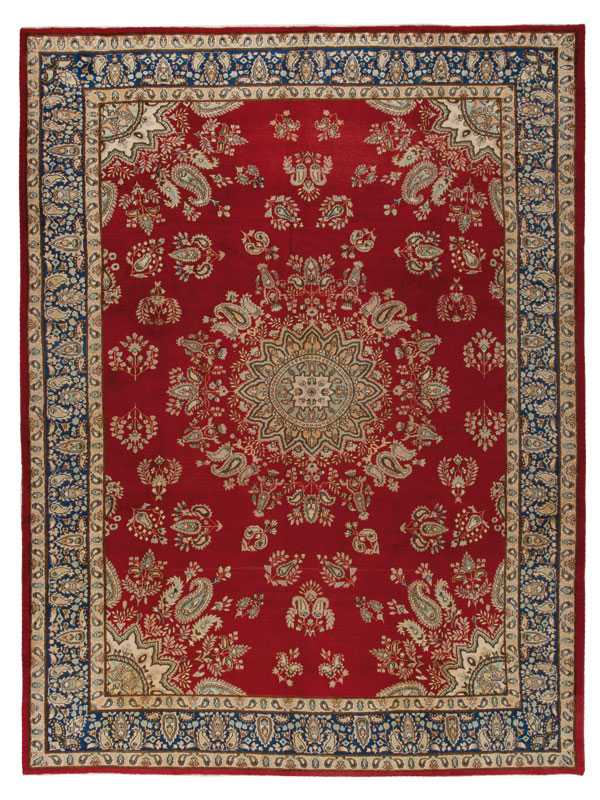 antico tappeto kirman con medaglione centrale e motivi decorativi dorati a goccia sul campo rosso e sullo spesso bordo blu