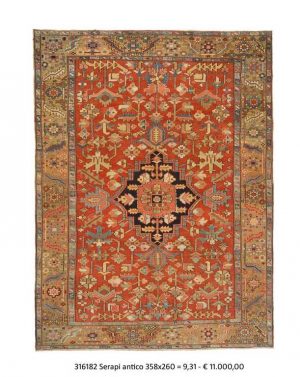 Tappeto persiano serapi con medaglione centrale rosso e blu su campo rosso con dettagli decorativi geometrici stilizzati sul campo e sullo spesso bordo del tappeto