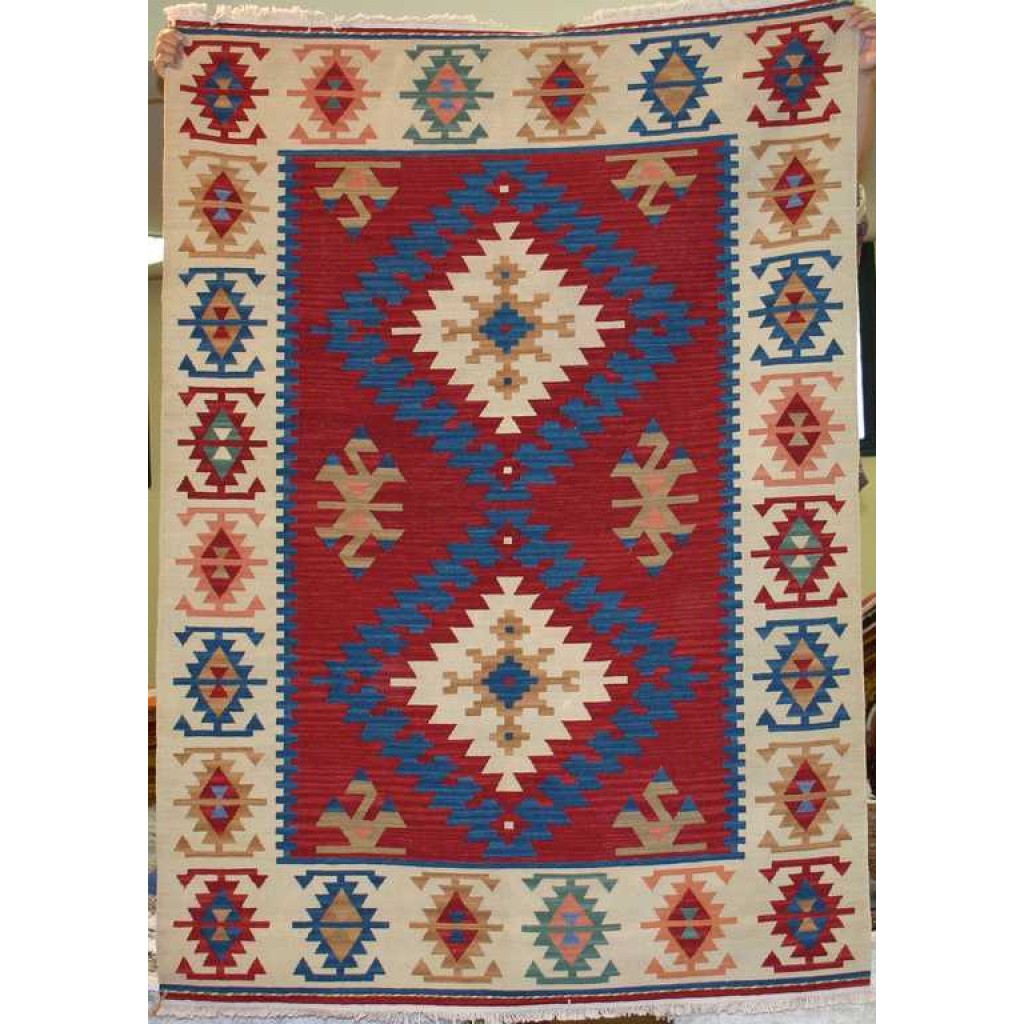 Tappeto contemporaneo kilim lana con doppio medaglione centrale uncinato su fondo rosso e motivi decorativi geometrici astratti su bordo bianco spesso