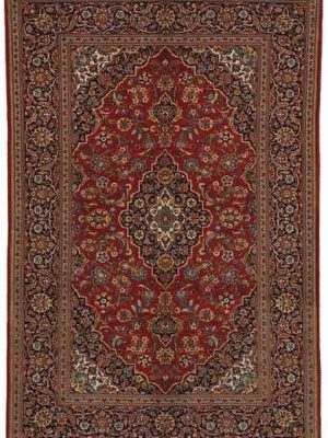 Tappeto persiano Keshan con medaglione centrale nero e intricati dettagli decorativi su sfondo rosso e spesso bordo.