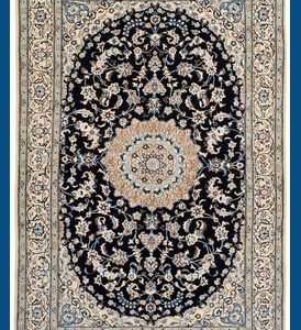 Tappeto persiano Nain nola, con medaglione geometrico centrale bianco decorato con motivi floreali intricati, su sfondo blu e intricati dettagli decorativi sullo spesso bordo bianco.