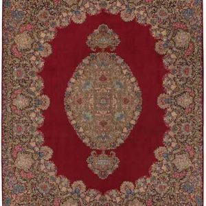 Tappeto persiano Kirman imperiale, con medaglione geometrico centrale su sfondo rosso e intricati dettagli decorativi sullo spesso bordo.