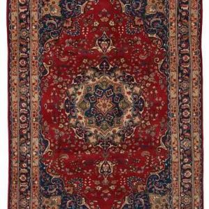 Tappeto persiano Mashad con medaglione geometrico centrale bianco e blu, e intricati dettagli decorativi geometrici su sfondo rosso, con spesso bordo blu.