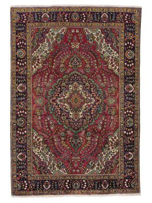 tappeto persiano tabriz con medaglione centrale e intricate decorazioni floreali e su sfondo rosso e con spesso bordo.