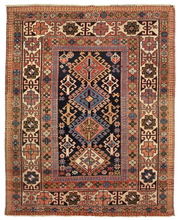 Tappeto shirvan antico con quattro medaglioni geometrici uncinati centrali rossi, blu e gialli su sfondo nero e decorazioni geometriche floreali e astratte. Presenta uno spesso bordo con motivi decorativi geometrici e floreali gialli, neri e azzurri su sfondo rosso