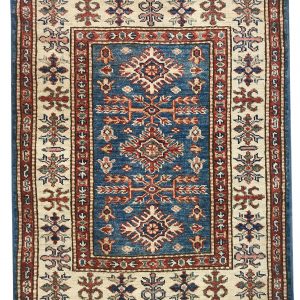 tappeto decorativo lesghi con medaglione centrale su sfondo blu, spesso bordo bianco e rosso e motivi decorativi floreali geometrici