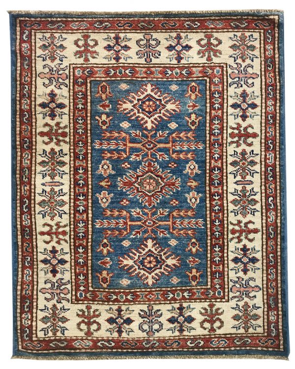 tappeto decorativo lesghi con medaglione centrale su sfondo blu, spesso bordo bianco e rosso e motivi decorativi floreali geometrici