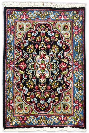 tappeto classico persiano kirma con medaglinoe centrale bianco su sfondo nero e verde, con decorazioni floreali rosse, verdi e azzurre e bordo blu