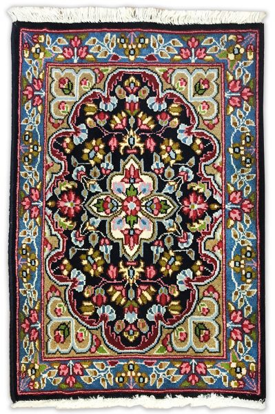 tappeto classico persiano kirma con medaglinoe centrale bianco su sfondo nero e verde, con decorazioni floreali rosse, verdi e azzurre e bordo blu