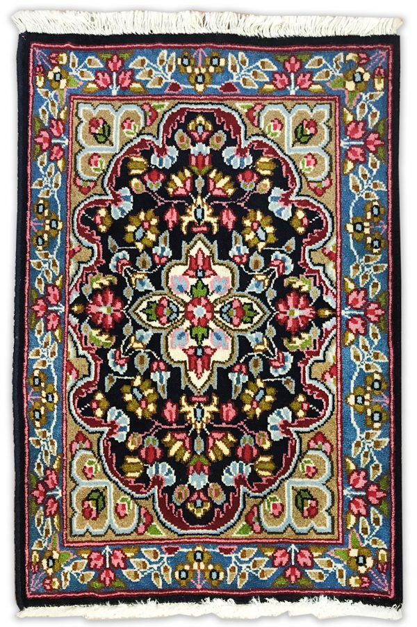 tappeto classico persiano kirma con medaglinoe centrale bianco su sfondo nero e verde, con decorazioni floreali rosse, verdi e azzurre e bordo blu