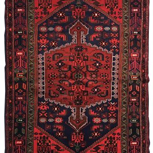 tappeto persiano originale khamse rosso e blu con medaglione centrale e disegni geometrici di fiori e piante bianchi, neri e rossi