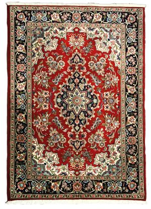tappeto persiano qum o qom shareza con medaglione centrale nero su sfondo rosso e decorazioni floreali su bordo nero