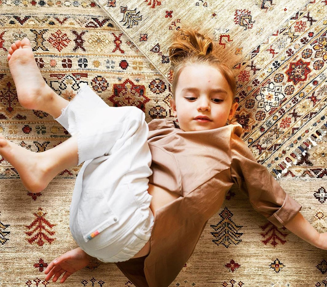 Bambina distesa su tappeti classici orientali Artorient