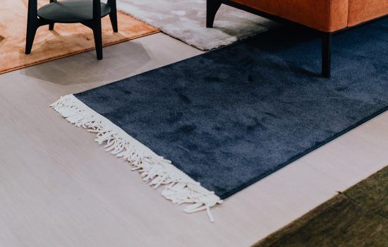 salotto moderno con tris di tappeti contemporanei Artorient per delimitare le zone conversazione