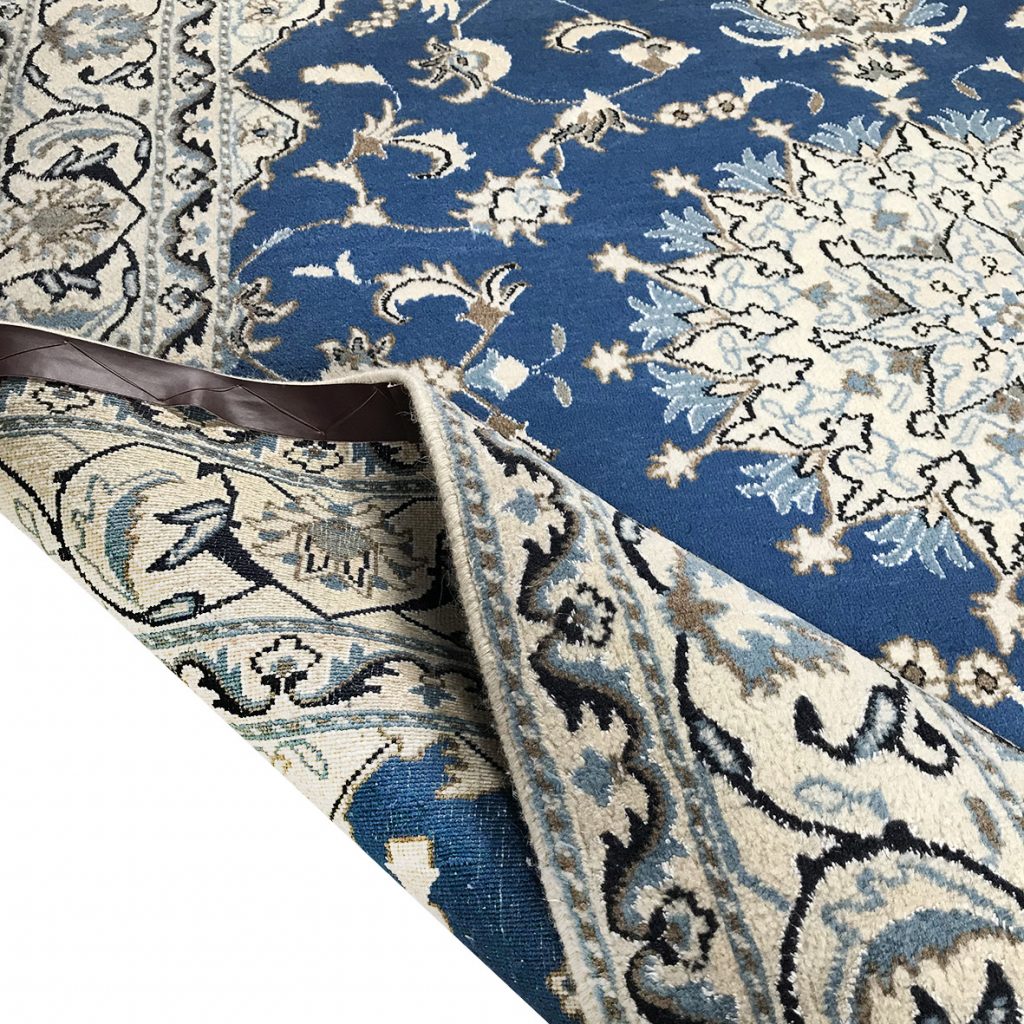 tappeto nain piegato per mostrare parte del retro, così da controllare la qualità del tappeto