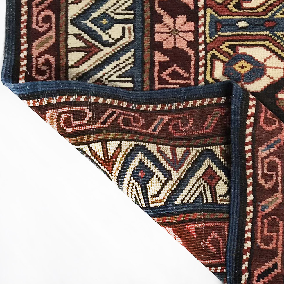 tappeto shirvan perpedil piegato per mostrare il retro, uno dei segnali di qualità di un tappeto