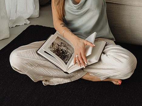 donna seduta su un tappeto con un libro