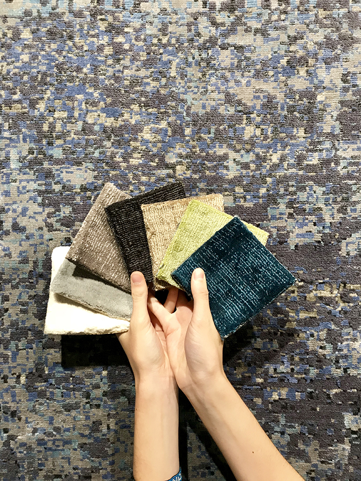 donna con campioni di tessuto su tappeto moderno grigio scuro