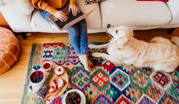 tappeto kilim sotto divano moderno bianco con donna che lavora al laptop e cane